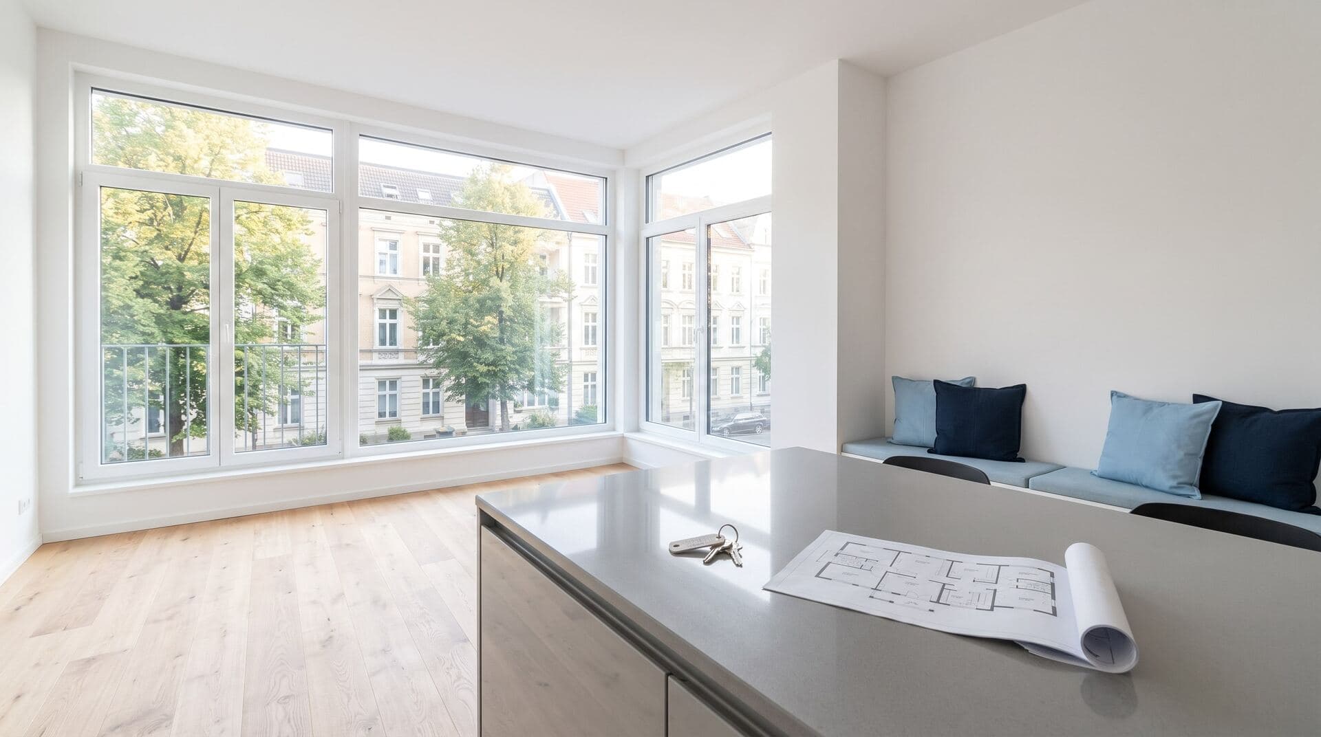 Helle, leere Wohnung mit Schlüsselbund und Grundriss auf der Kücheninsel (Symbolbild)